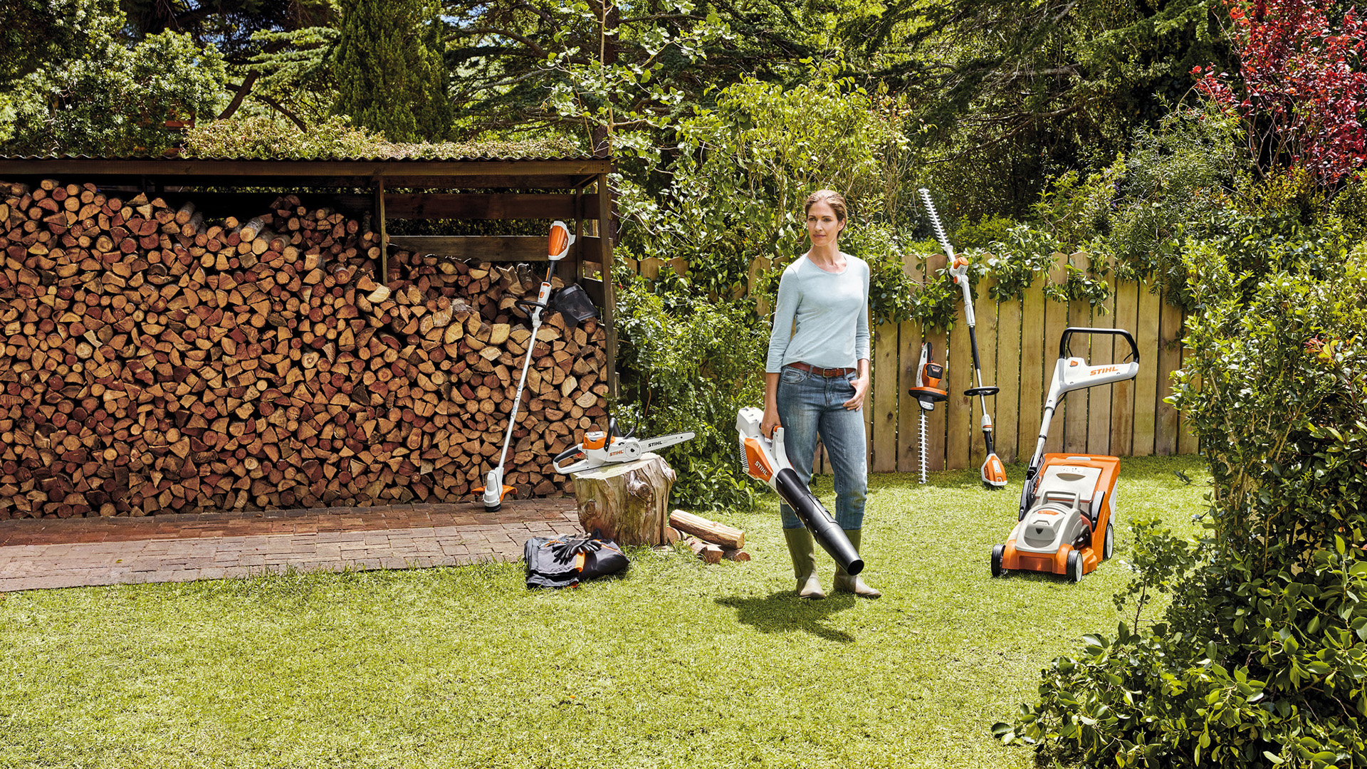 Žena stoji u dvorištu ispred gomile drva s uređajima iz AK sistema 