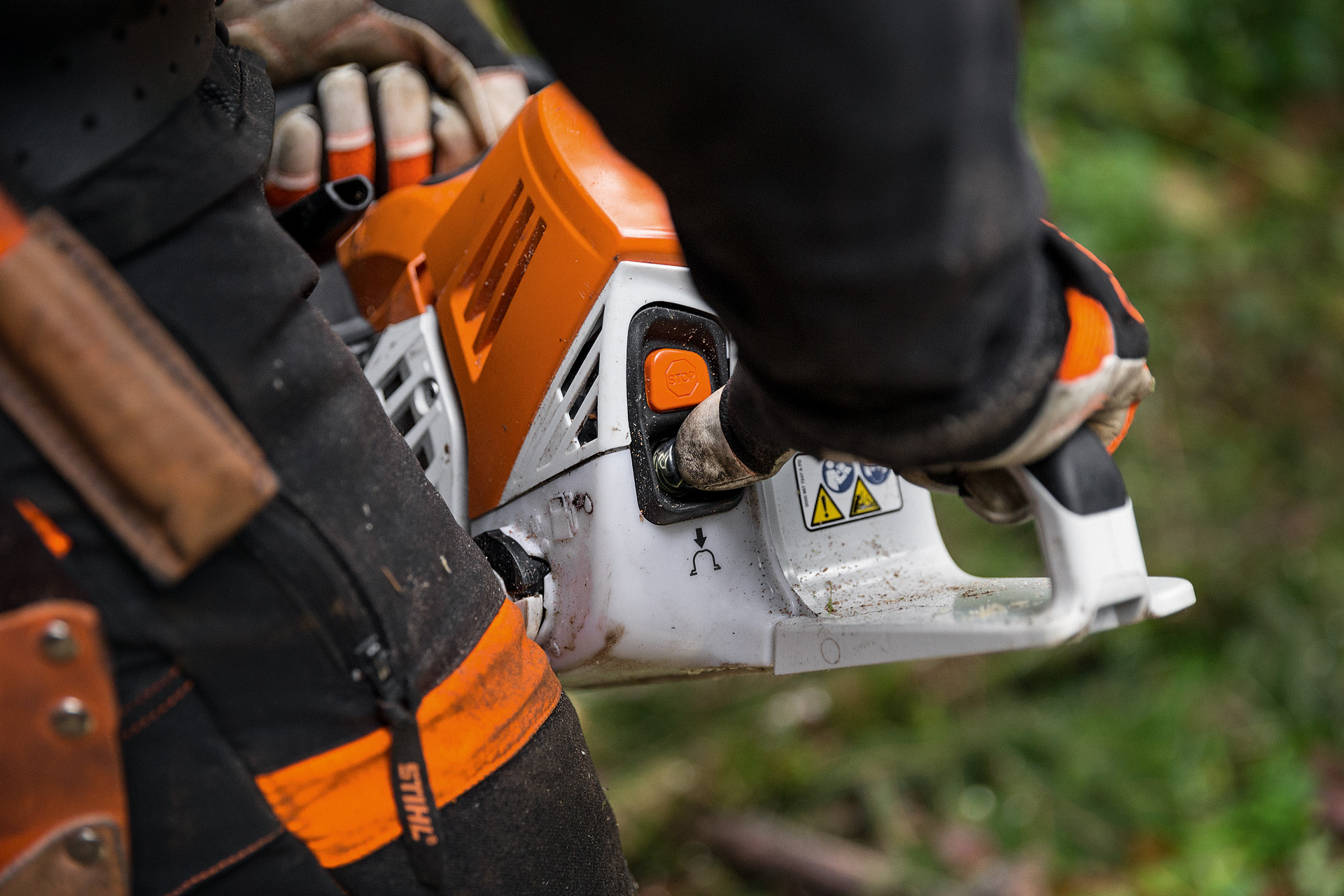 Osoba u zaštitnoj odeći pokreće benzinsku lančanu testeru STIHL MS 500i na tlu listopadne šume