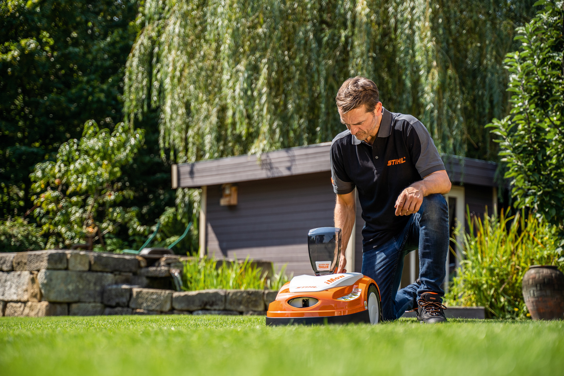 Radnik STIHL specijalizovane prodavnice u dvorištu programira plan košenja STIHL iMOW robotske kosačice