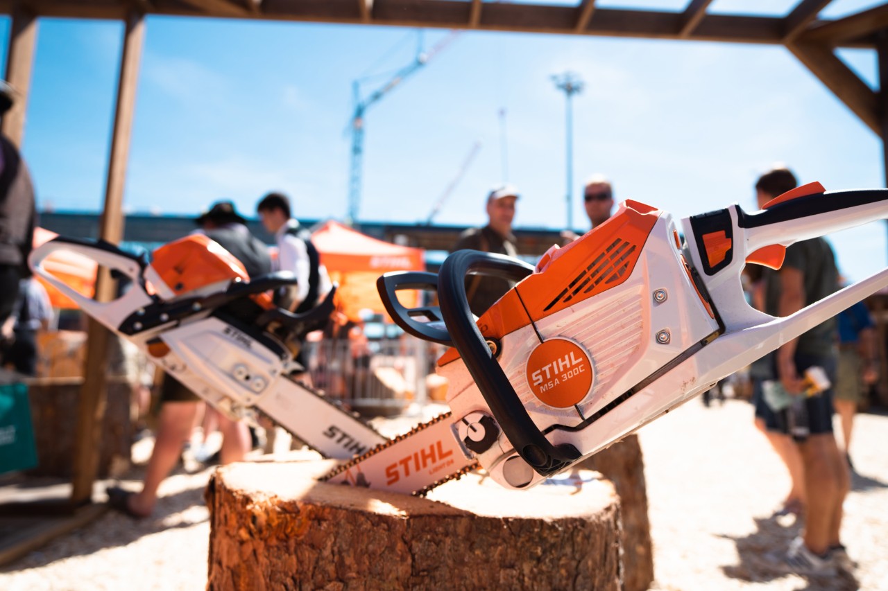 STIHL štand na sajmu u zatvorenom prostoru, između ostalog, sa izloženim motornim testerama i zaštitnom odećom